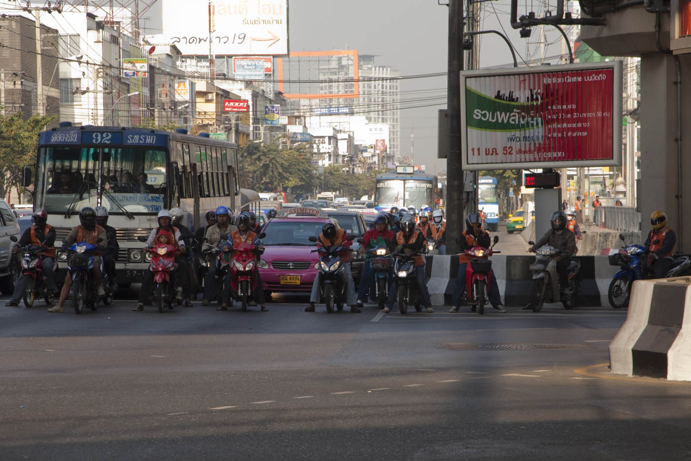 Bangkok motorcycle taxi drivers wait at a light