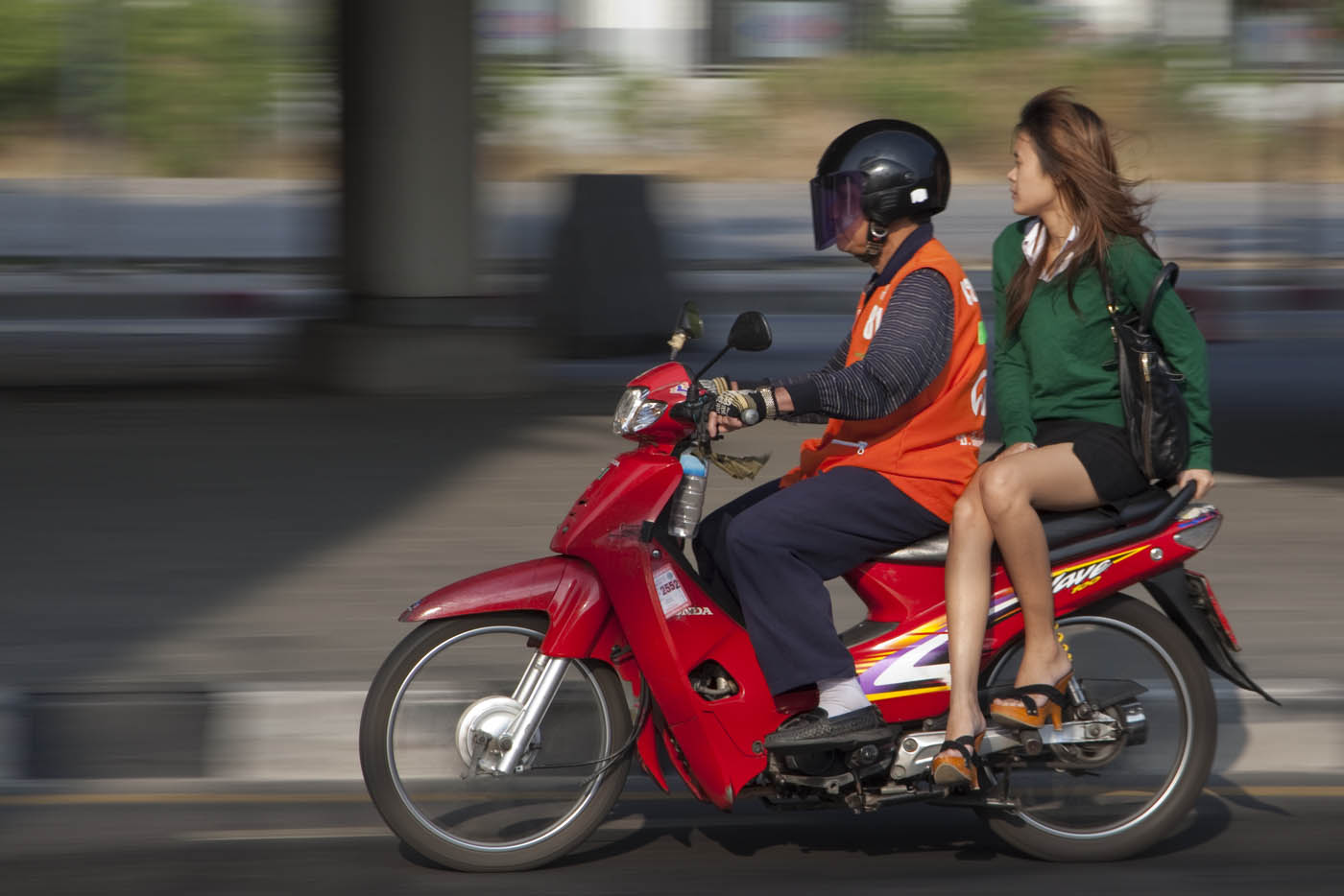 Bagnkok woman with amazing legs rides a Bangkok motorcycle